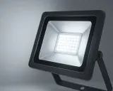 Projecteur LED extérieur noir avec une grille de diodes lumineuses blanches.