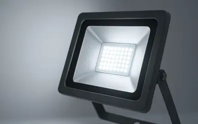 Projecteur LED extérieur noir avec une grille de diodes lumineuses blanches.