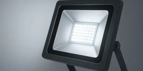 Projecteur LED extérieur noir avec une grille de diodes lumineuses blanches.