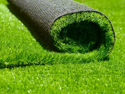 Rouleau de gazon synthétique vert vif, montrant le dessous noir et le dessus en fibres.