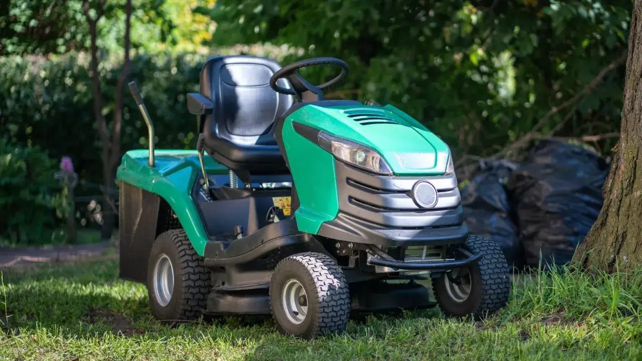 Tondeuse autoport&eacute;e verte, pr&ecirc;te pour l'entretien du jardin. Une aide pr&eacute;cieuse pour savoir quelle tondeuse choisir.