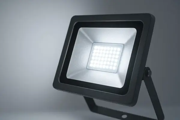 Projecteur LED extérieur noir avec une grille de diodes lumineuses blanches.